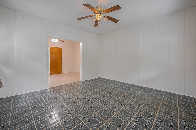 512 Threlkeld St, Houston, TX 77007 - spare room with a ceiling fan, dark flooring, a textured ceiling, and a decorative wall