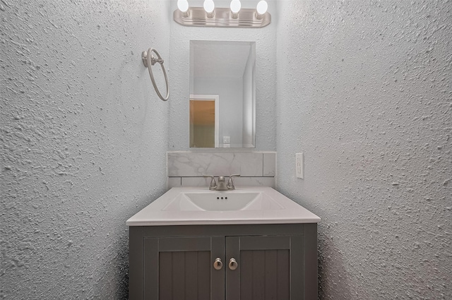 512 Threlkeld St, Houston, TX 77007 - bathroom featuring a textured wall, vanity, and decorative backsplash