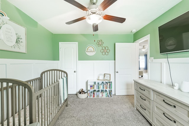 24218 Birchwood Creek Ct, Spring, TX 77389 - bedroom with light colored carpet, a wainscoted wall, a crib, a decorative wall, and a ceiling fan