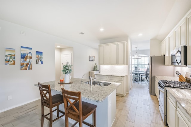 24218 Birchwood Creek Ct, Spring, TX 77389 - kitchen with appliances with stainless steel finishes, light stone counters, a kitchen breakfast bar, a kitchen island with sink, and recessed lighting