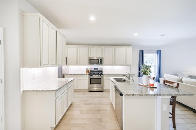 24218 Birchwood Creek Ct, Spring, TX 77389 - kitchen with stainless steel appliances, backsplash, recessed lighting, a kitchen bar, and light stone countertops