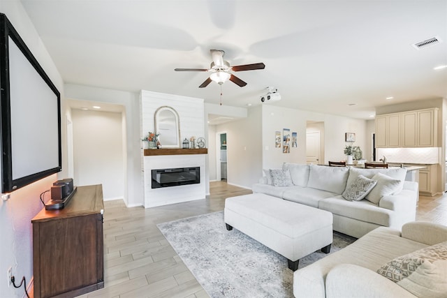 24218 Birchwood Creek Ct, Spring, TX 77389 - living area with a ceiling fan, recessed lighting, light wood-type flooring, and a glass covered fireplace