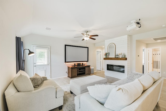 24218 Birchwood Creek Ct, Spring, TX 77389 - living room featuring light wood-type flooring, a ceiling fan, and a glass covered fireplace