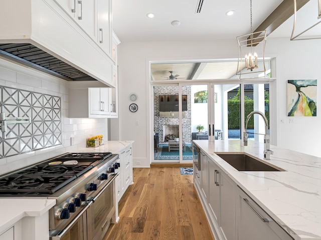 518 Hallie Dr, Houston, TX 77024 - kitchen with ventilation hood, range with two ovens, tasteful backsplash, recessed lighting, and light wood-style floors