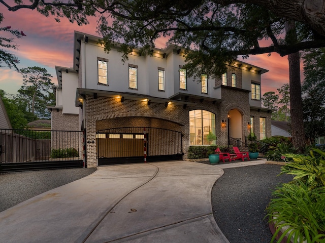 518 Hallie Dr, Houston, TX 77024 - view of front of house featuring concrete driveway, an attached garage, brick siding, stucco siding, and a gate