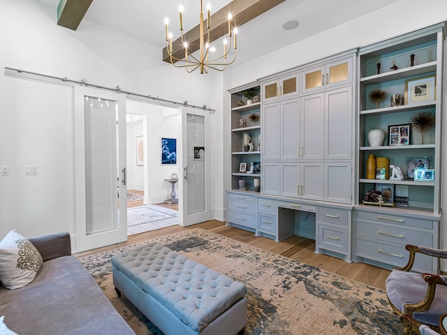 518 Hallie Dr, Houston, TX 77024 - home office with light wood-style flooring, a chandelier, built in desk, and a barn door