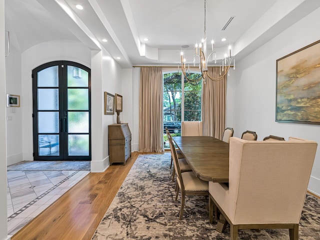 518 Hallie Dr, Houston, TX 77024 - dining area featuring french doors, a chandelier, recessed lighting, a tray ceiling, and arched walkways