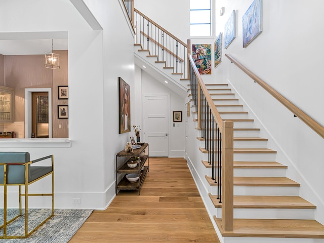 518 Hallie Dr, Houston, TX 77024 - staircase with a towering ceiling, wood finished floors, and a chandelier