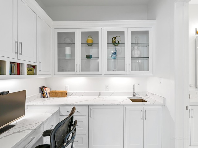 518 Hallie Dr, Houston, TX 77024 - kitchen with white cabinetry, light stone counters, and glass insert cabinets