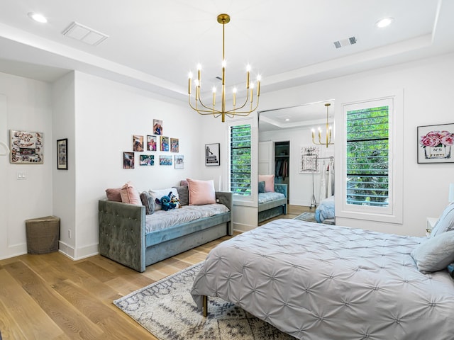 518 Hallie Dr, Houston, TX 77024 - bedroom featuring a chandelier, a tray ceiling, multiple windows, recessed lighting, and wood finished floors
