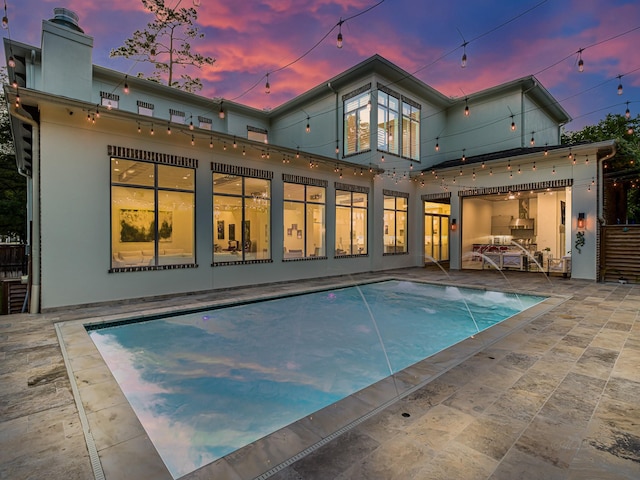 518 Hallie Dr, Houston, TX 77024 - back of property with a patio, an outdoor pool, a chimney, and stucco siding
