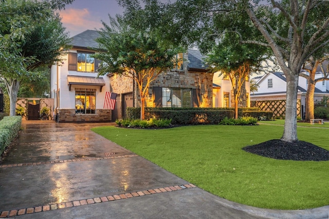 7614 Brykerwoods Dr, Houston, TX 77055 - view of front facade featuring stone siding, concrete driveway, stucco siding, and a lawn