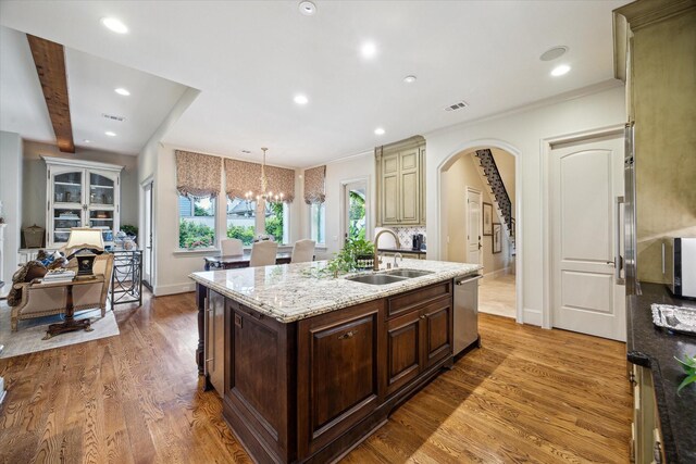 7614 Brykerwoods Dr, Houston, TX 77055 - kitchen with stainless steel dishwasher, an island with sink, light stone counters, a chandelier, and light wood-style floors