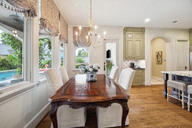 7614 Brykerwoods Dr, Houston, TX 77055 - dining room with a chandelier, arched walkways, light wood-type flooring, crown molding, and recessed lighting