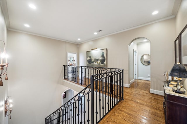 7614 Brykerwoods Dr, Houston, TX 77055 - hallway featuring arched walkways, an upstairs landing, crown molding, wood finished floors, and recessed lighting