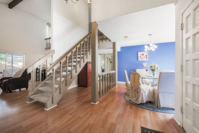 7642 Candlegreen Ln, Houston, TX 77071 - stairs featuring a chandelier, wood finished floors, and a high ceiling