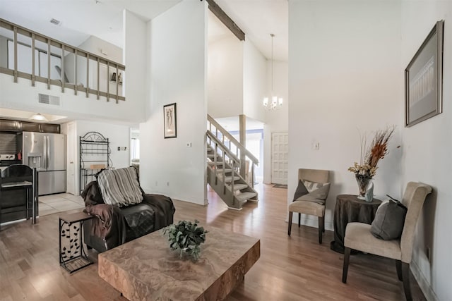 7642 Candlegreen Ln, Houston, TX 77071 - living area featuring a towering ceiling, stairway, light wood-type flooring, and a chandelier