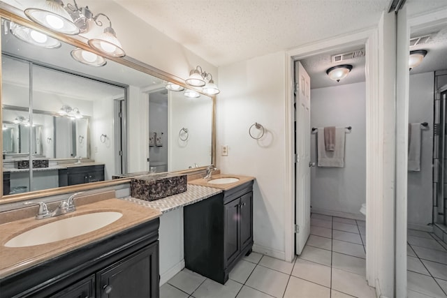 7642 Candlegreen Ln, Houston, TX 77071 - bathroom featuring tile patterned flooring, a textured ceiling, and double vanity