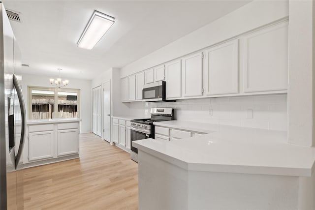 1714 Regal Blue Ct, Fresno, TX 77545 - kitchen with stainless steel appliances, a chandelier, decorative backsplash, light countertops, and a peninsula