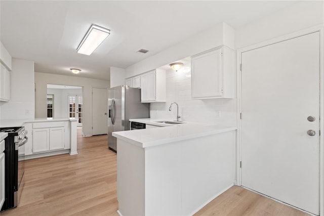1714 Regal Blue Ct, Fresno, TX 77545 - kitchen featuring appliances with stainless steel finishes, a peninsula, light wood-style flooring, light countertops, and white cabinets