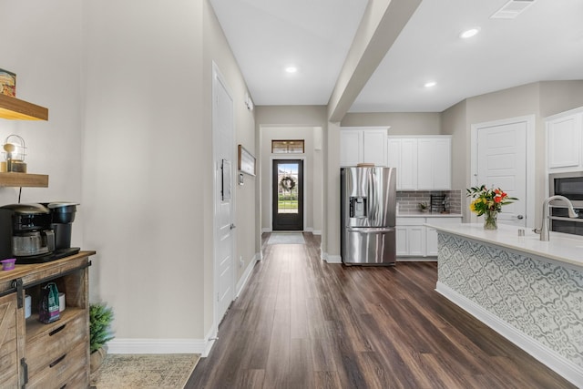 1926 Kingston Meadow Ln, Katy, TX 77494 - kitchen featuring stainless steel appliances, light countertops, dark wood-style floors, white cabinetry, and backsplash