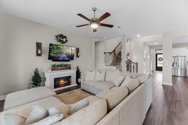 1926 Kingston Meadow Ln, Katy, TX 77494 - living area featuring dark wood-style flooring, ceiling fan, stairs, a stone fireplace, and recessed lighting