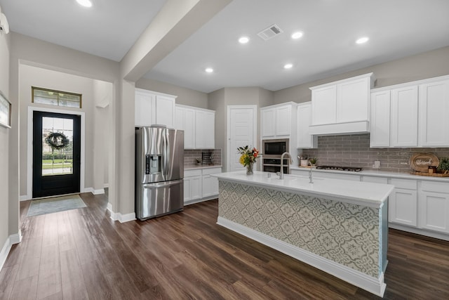 1926 Kingston Meadow Ln, Katy, TX 77494 - kitchen with stainless steel appliances, light countertops, decorative backsplash, a center island with sink, and dark wood-style flooring