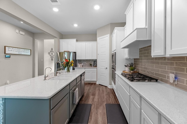 1926 Kingston Meadow Ln, Katy, TX 77494 - kitchen featuring stainless steel appliances, backsplash, white cabinets, dark wood-style floors, and light stone counters