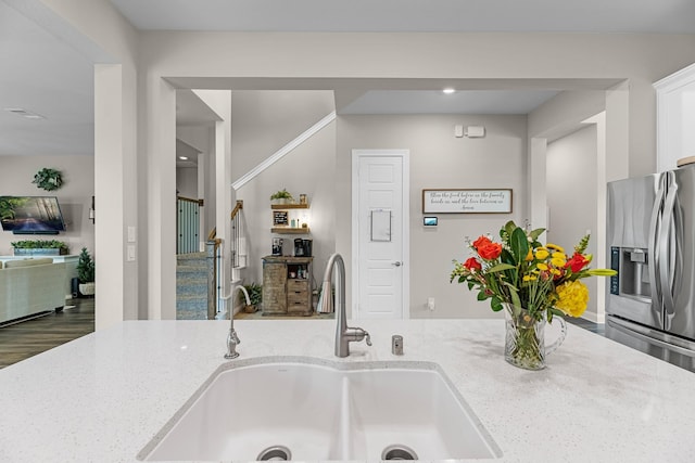 1926 Kingston Meadow Ln, Katy, TX 77494 - kitchen with stainless steel fridge, light stone counters, white cabinets, and recessed lighting