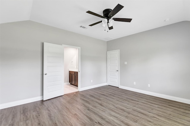 214 Kickapoo Dr, Anahuac, TX 77514 - unfurnished bedroom featuring vaulted ceiling, wood finished floors, ensuite bathroom, and ceiling fan