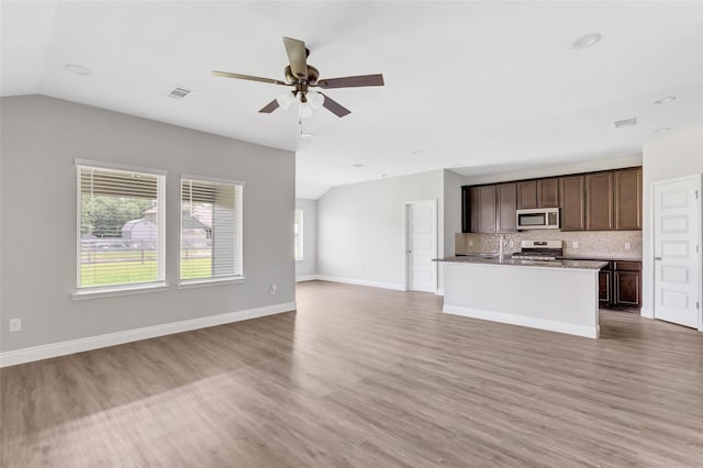 214 Kickapoo Dr, Anahuac, TX 77514 - unfurnished living room featuring lofted ceiling, a ceiling fan, and light wood-style floors