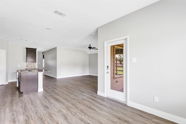 214 Kickapoo Dr, Anahuac, TX 77514 - kitchen with a ceiling fan, wood finished floors, open floor plan, and dark brown cabinets