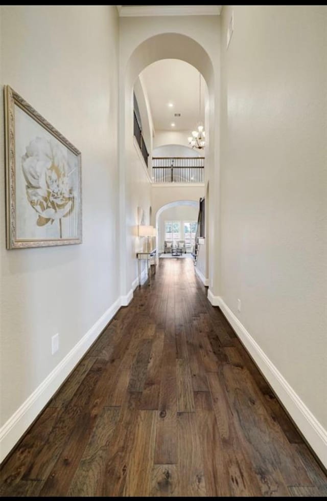 5011 Anthony Springs Ln, Sugar Land, TX 77479 - corridor featuring arched walkways, wood finished floors, a chandelier, and a high ceiling