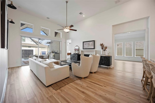 11822 Creekside Shore Cir, Cypress, TX 77433 - living area with light wood finished floors, ceiling fan, plenty of natural light, and a towering ceiling