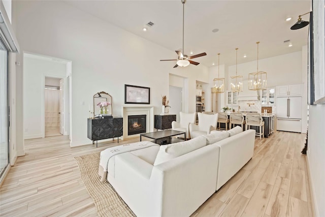 11822 Creekside Shore Cir, Cypress, TX 77433 - living room with a high ceiling, light wood-style flooring, ceiling fan, recessed lighting, and a chandelier