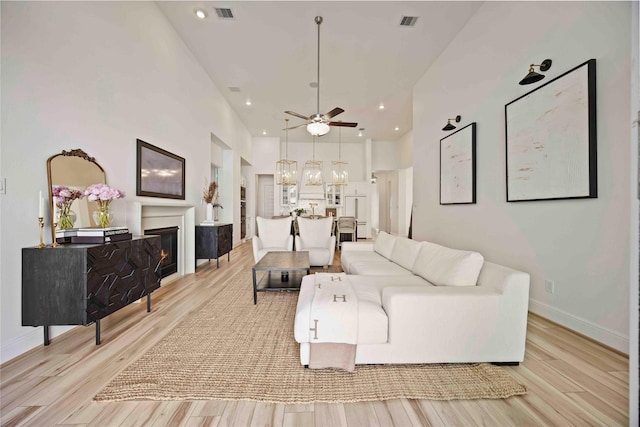 11822 Creekside Shore Cir, Cypress, TX 77433 - living area featuring a glass covered fireplace, light wood-style flooring, recessed lighting, ceiling fan, and a chandelier