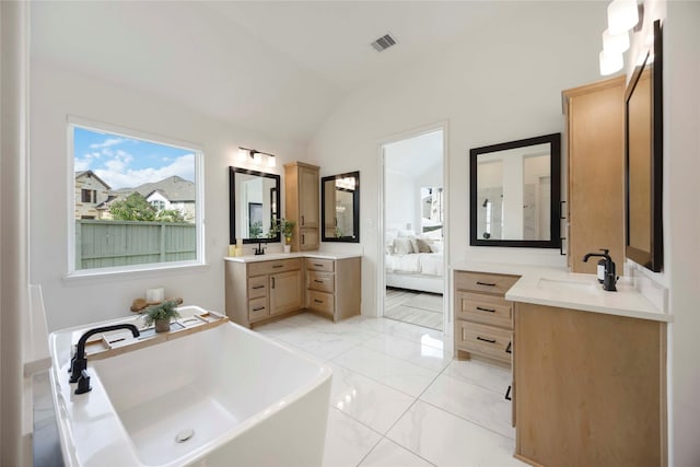 11822 Creekside Shore Cir, Cypress, TX 77433 - ensuite bathroom with two vanities, a freestanding tub, lofted ceiling, and marble look tile flooring