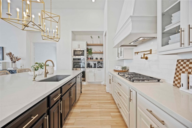 11822 Creekside Shore Cir, Cypress, TX 77433 - kitchen featuring premium range hood, appliances with stainless steel finishes, white cabinets, light countertops, and tasteful backsplash