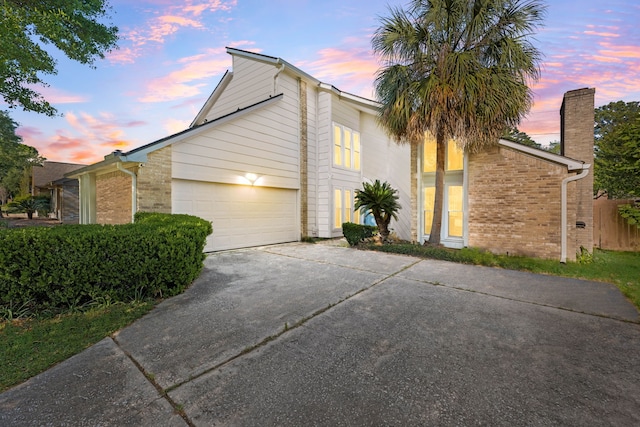 7306 Creek Crest Dr, Houston, TX 77095 - view of property exterior featuring concrete driveway, brick siding, an attached garage, and a chimney