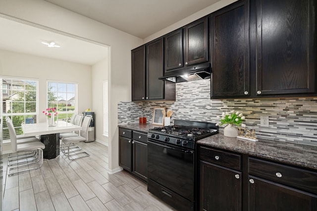 14722 Ruddy Duck Ln, Houston, TX 77049 - kitchen featuring black gas range oven, under cabinet range hood, tasteful backsplash, and dark brown cabinetry
