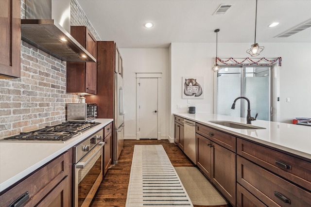 1422 Rosedale St, Houston, TX 77004 - kitchen with stainless steel appliances, wall chimney exhaust hood, light countertops, dark wood finished floors, and recessed lighting