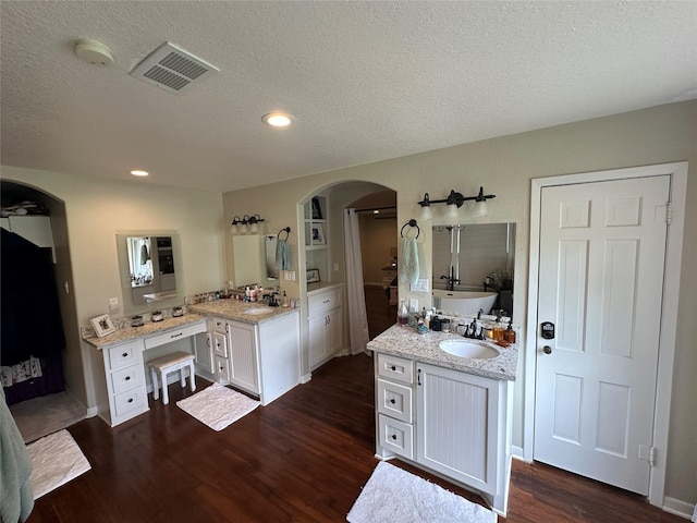 2201 Oleander Dr, Dickinson, TX 77539 - bathroom with wood finished floors, a textured ceiling, two vanities, recessed lighting, and a freestanding tub