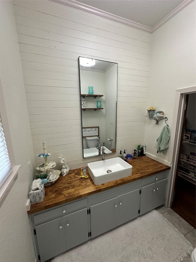 2201 Oleander Dr, Dickinson, TX 77539 - bathroom featuring crown molding, vanity, and wood walls