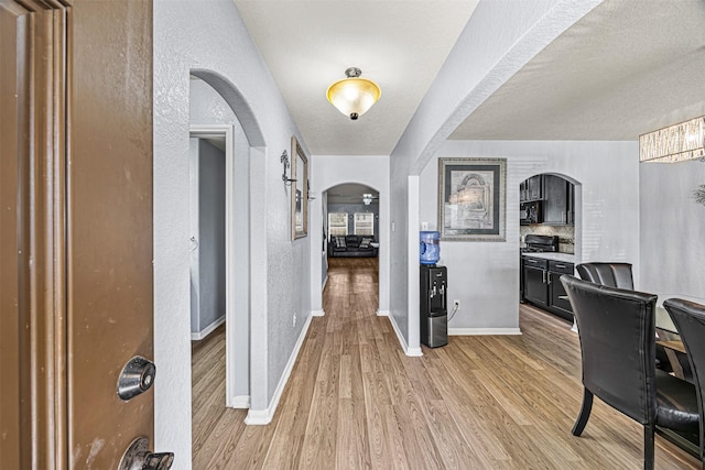 15307 Meandering Post Trl, Houston, TX 77044 - entrance foyer featuring arched walkways, light wood-type flooring, and a textured wall