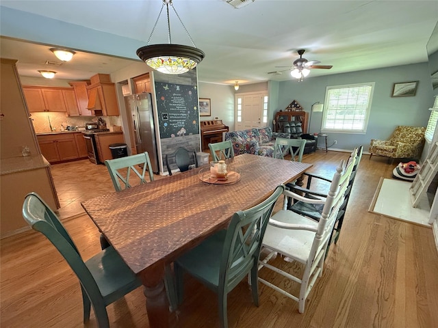 132 Daisy St, Lake Jackson, TX 77566 - dining room featuring ceiling fan, light wood finished floors, and a fireplace