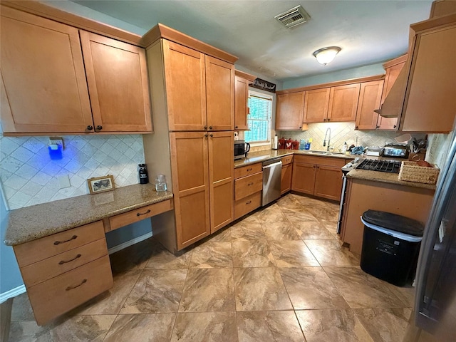 132 Daisy St, Lake Jackson, TX 77566 - kitchen with appliances with stainless steel finishes, built in study area, tasteful backsplash, and light stone countertops