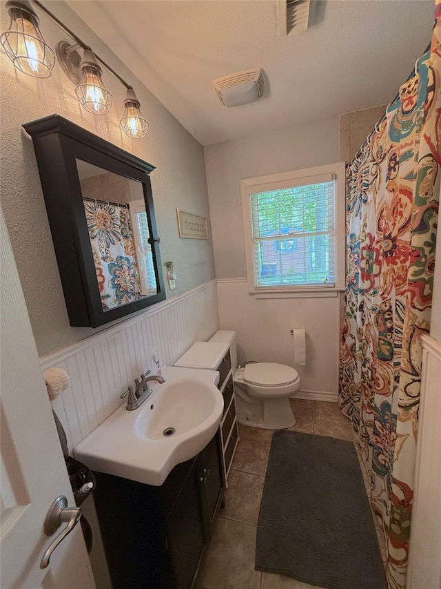 132 Daisy St, Lake Jackson, TX 77566 - bathroom with vanity, tile patterned flooring, a wainscoted wall, and a shower with shower curtain