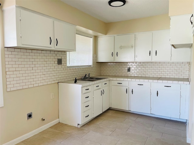 300 Robbie St, La Marque, TX 77568 - kitchen featuring backsplash, white cabinetry, light tile patterned flooring, and tile countertops