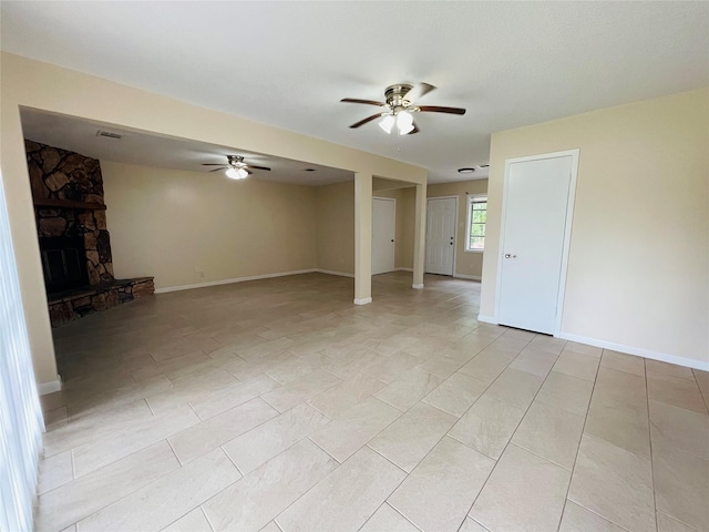 300 Robbie St, La Marque, TX 77568 - unfurnished living room with a ceiling fan, a stone fireplace, and light tile patterned floors
