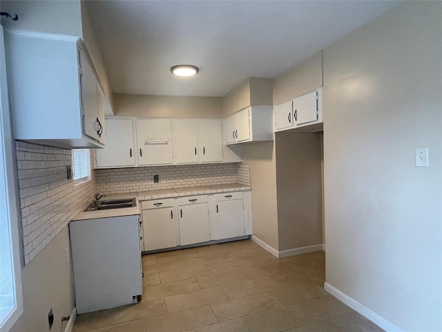 300 Robbie St, La Marque, TX 77568 - kitchen featuring tasteful backsplash, white cabinetry, light countertops, and light tile patterned floors